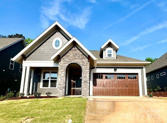 craftsman house with a garage, a front lawn, stone siding, and concrete driveway