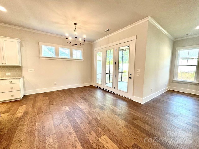 unfurnished dining area with crown molding, dark wood finished floors, and plenty of natural light