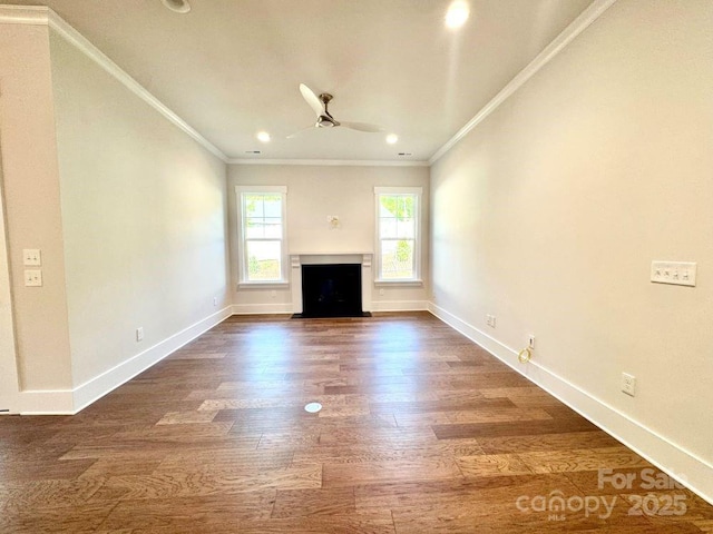 unfurnished living room with a fireplace with flush hearth, dark wood finished floors, ornamental molding, and ceiling fan