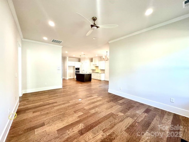 unfurnished living room with ceiling fan, visible vents, crown molding, baseboards, and recessed lighting