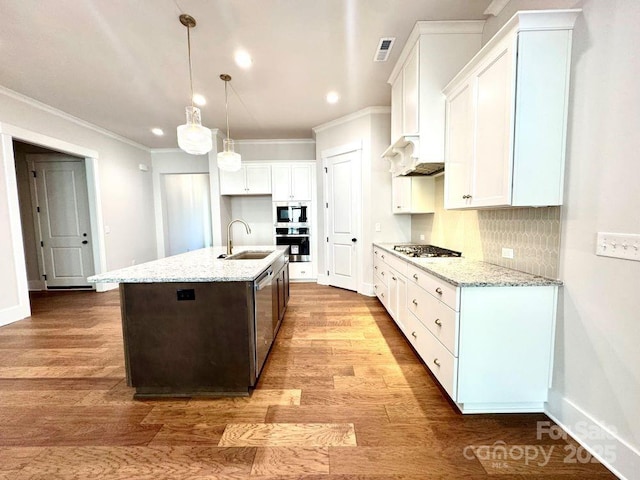 kitchen featuring crown molding, wood finished floors, white cabinetry, a sink, and appliances with stainless steel finishes