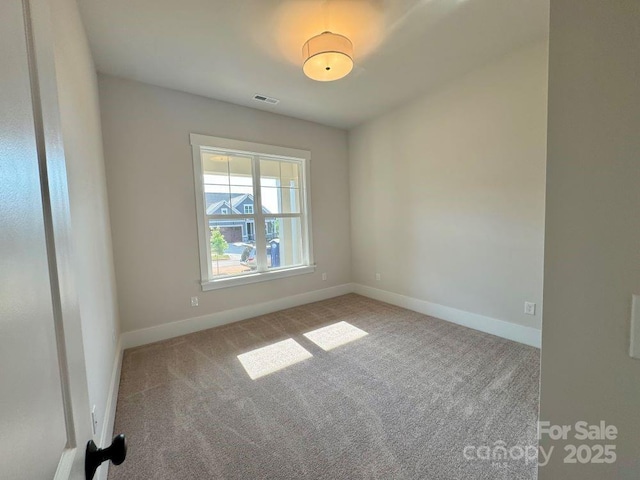 carpeted empty room featuring visible vents and baseboards