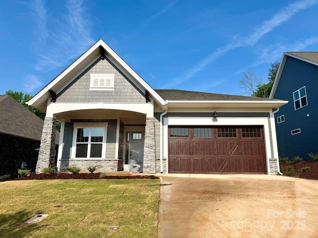 craftsman inspired home featuring concrete driveway, a front yard, stone siding, and a garage