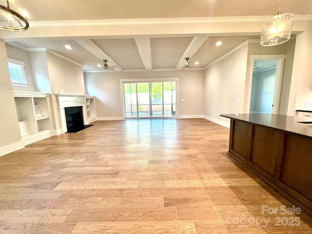 unfurnished living room with light wood-style floors, baseboards, ornamental molding, and a fireplace