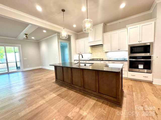 kitchen featuring decorative backsplash, ornamental molding, baseboards, a sink, and appliances with stainless steel finishes