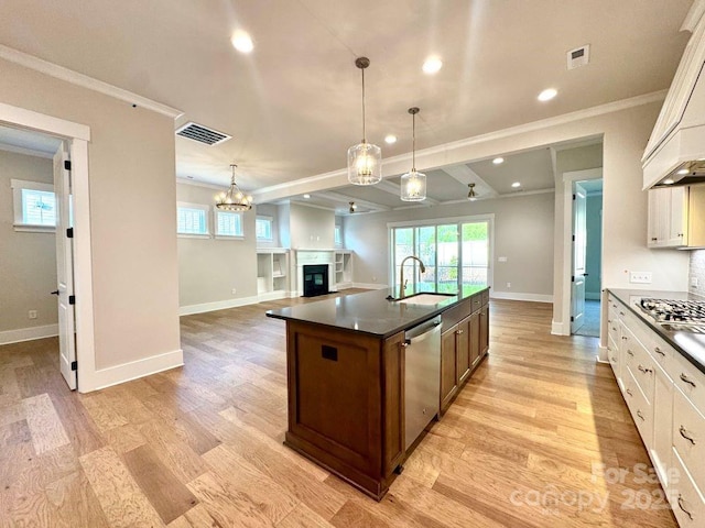 kitchen featuring dark countertops, baseboards, a sink, light wood-style flooring, and stainless steel appliances