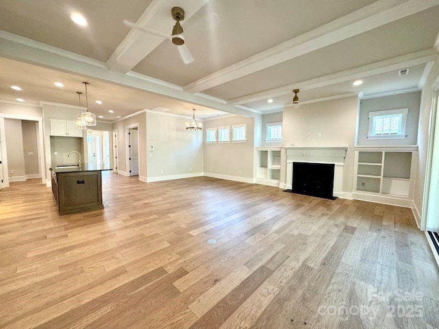 unfurnished living room featuring crown molding, beam ceiling, baseboards, light wood finished floors, and ceiling fan with notable chandelier