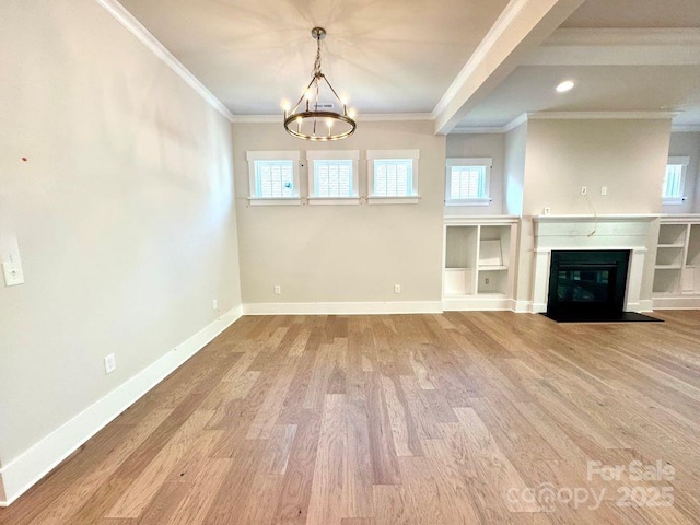 unfurnished living room with baseboards, a chandelier, ornamental molding, and wood finished floors
