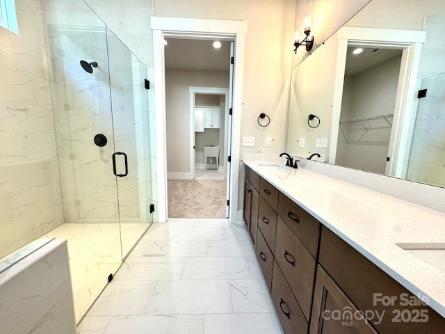 full bath featuring double vanity, a sink, marble finish floor, and a shower stall