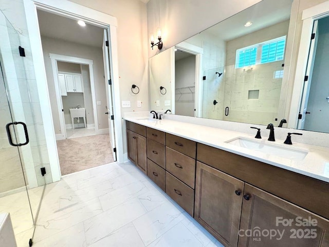 full bath with a sink, a spacious closet, a shower stall, and marble finish floor