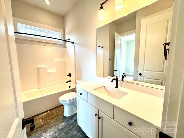 full bath featuring vanity, washtub / shower combination, and toilet