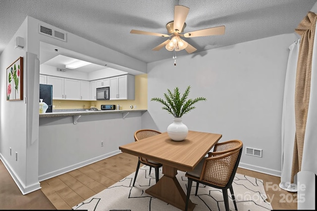 1832 J Julian Ln Unit D, Charlotte, NC 28208 - dining room with wood finished floors, a ceiling fan, baseboards, and a textured ceiling