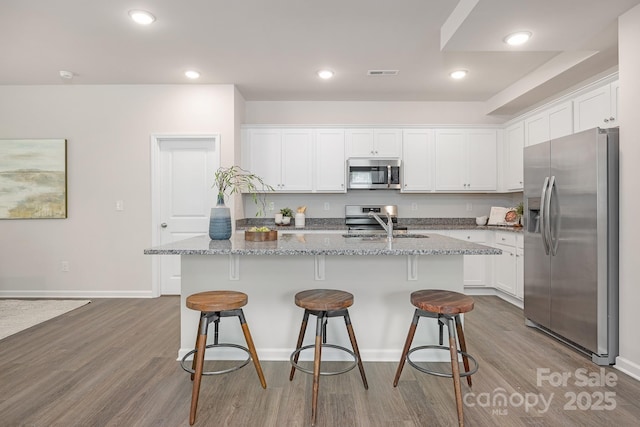 700 Sunset Pointe Dr, Salisbury, NC 28146 - kitchen featuring stainless steel appliances, dark wood-style floors, white cabinets, light stone countertops, and recessed lighting