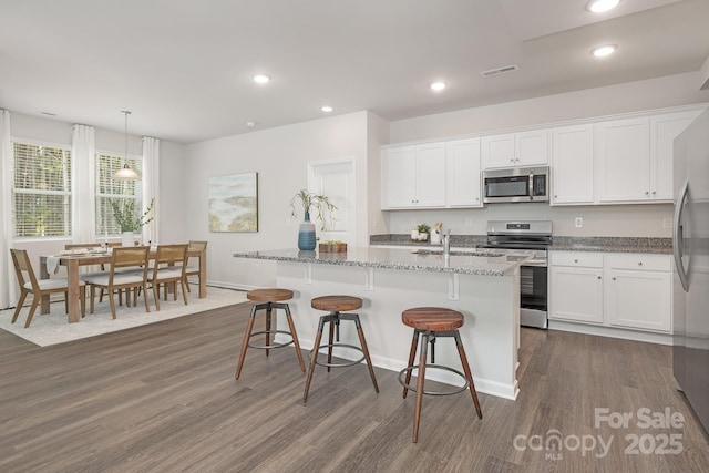 700 Sunset Pointe Dr, Salisbury, NC 28146 - kitchen featuring appliances with stainless steel finishes, white cabinets, dark wood-style flooring, light stone counters, and recessed lighting