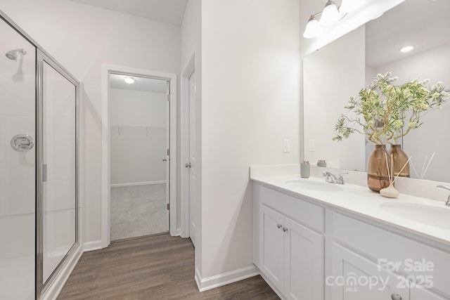 700 Sunset Pointe Dr, Salisbury, NC 28146 - bathroom with double vanity, wood finished floors, a shower stall, and a spacious closet