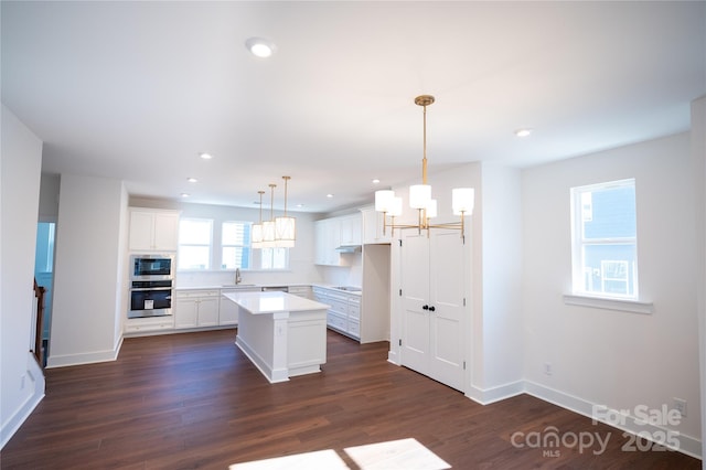 kitchen featuring white cabinetry, dark wood-style floors, a kitchen island, and appliances with stainless steel finishes