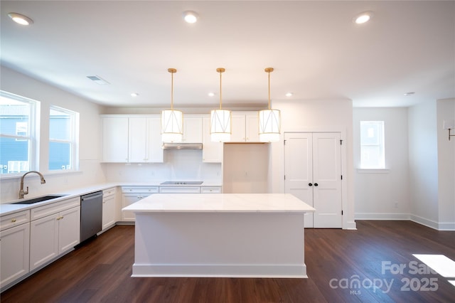 kitchen featuring black electric cooktop, a kitchen island, a sink, dark wood-style floors, and stainless steel dishwasher