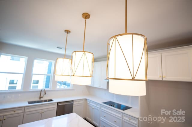 kitchen with light countertops, a sink, black electric stovetop, and stainless steel dishwasher