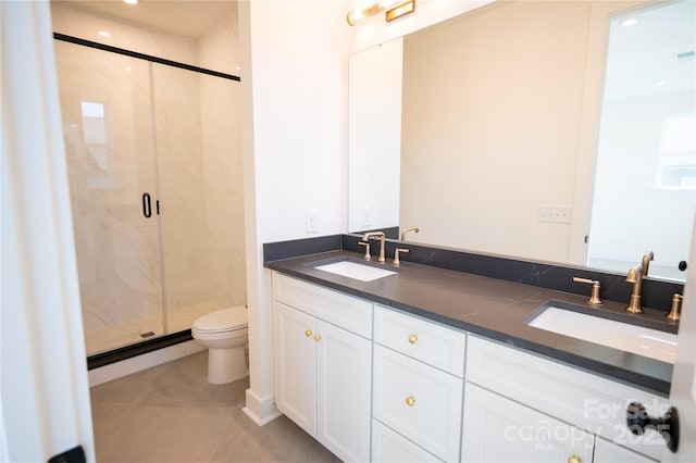 bathroom featuring double vanity, a sink, toilet, and a shower stall