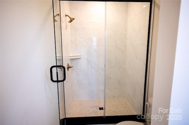 bathroom featuring toilet and a stall shower