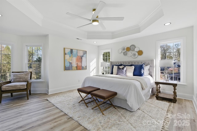 bedroom with a tray ceiling, multiple windows, and crown molding