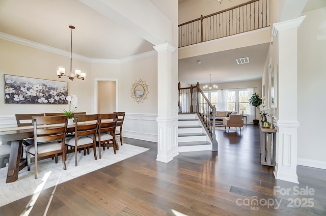 11144 Limehurst Pl, Charlotte, NC 28278 - dining room featuring a chandelier, ornate columns, wood finished floors, a wainscoted wall, and ornamental molding