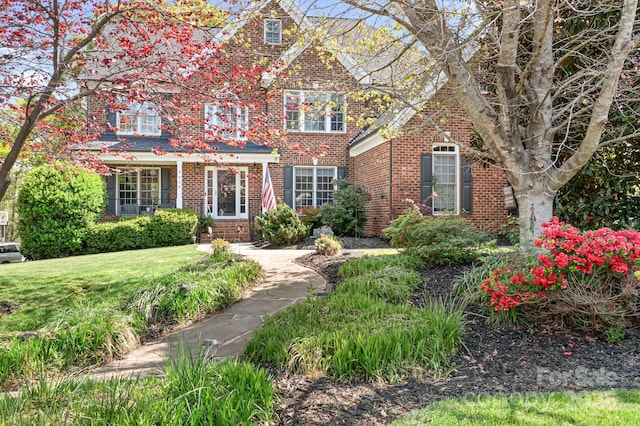 view of front of property featuring a front yard and brick siding