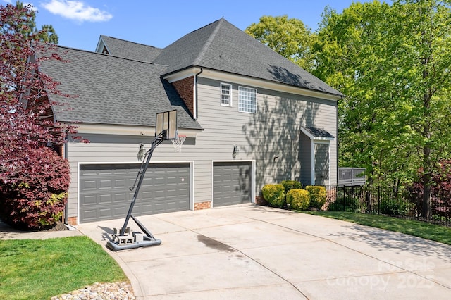 view of home's exterior with roof with shingles, driveway, and fence