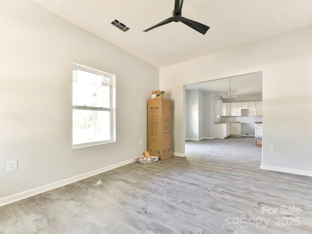 108 Graham St, Chester, SC 29706 - unfurnished living room with baseboards, light wood-style flooring, and ceiling fan with notable chandelier