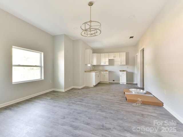 108 Graham St, Chester, SC 29706 - unfurnished living room featuring a sink, visible vents, an inviting chandelier, light wood-style flooring, and baseboards