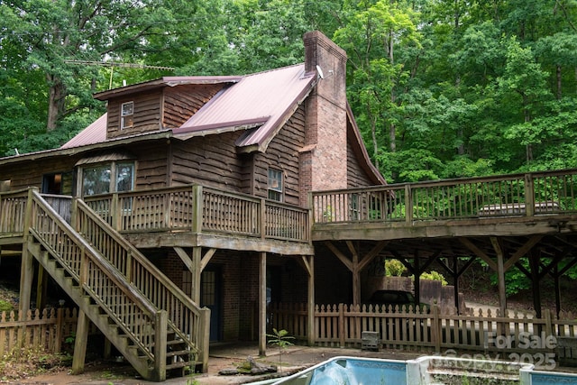 2610 Indian Grave Rd, Lenoir, NC 28645 - rear view of property featuring a deck, stairway, metal roof, a chimney, and a forest view