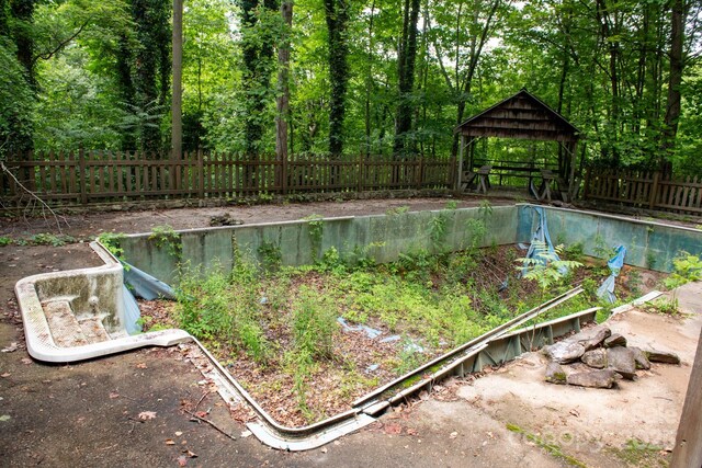 2610 Indian Grave Rd, Lenoir, NC 28645 - view of swimming pool with a gazebo, a fenced backyard, a view of trees, and a vegetable garden