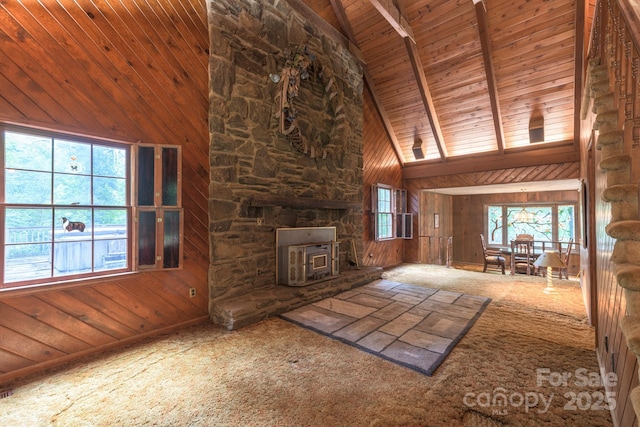 2610 Indian Grave Rd, Lenoir, NC 28645 - unfurnished living room featuring a wood stove, wood ceiling with exposed beams, wooden walls, high vaulted ceiling, and carpet floors