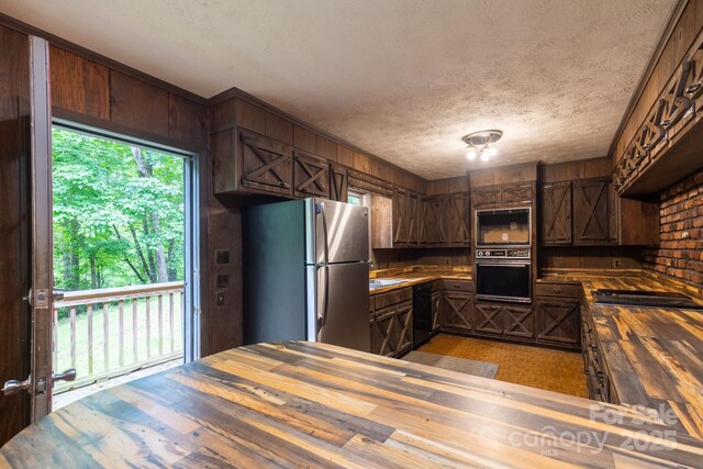 2610 Indian Grave Rd, Lenoir, NC 28645 - kitchen with wooden counters, oven, freestanding refrigerator, dishwasher, and wooden walls