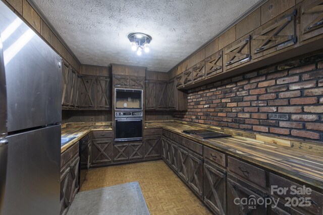 2610 Indian Grave Rd, Lenoir, NC 28645 - kitchen featuring black appliances, a textured ceiling, butcher block countertops, and dark brown cabinets