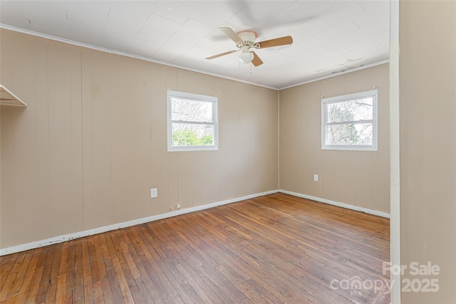 spare room featuring a wealth of natural light, crown molding, ceiling fan, and hardwood / wood-style floors