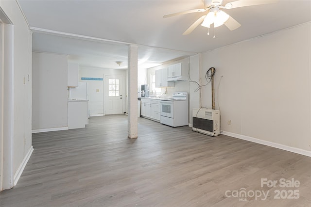 interior space with baseboards, light wood-style floors, and ceiling fan