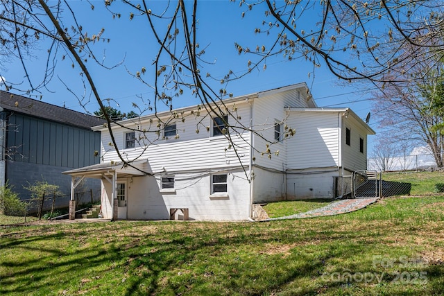 rear view of property with a lawn and fence