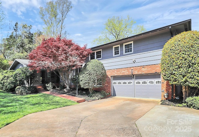 view of front of property with brick siding, concrete driveway, a garage, and a front lawn