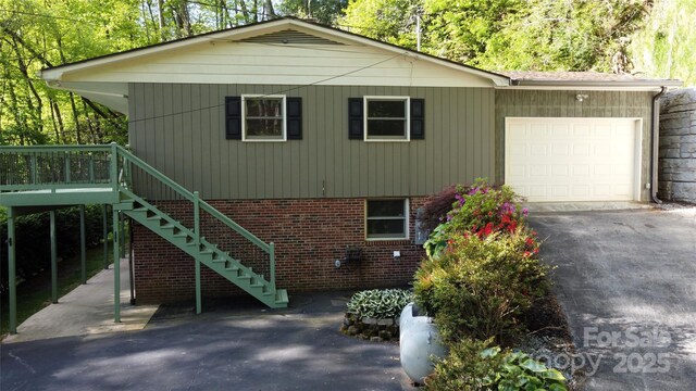 857 Country Club Dr, Maggie Valley, NC 28751 - view of front of house featuring an attached garage, brick siding, driveway, and stairs