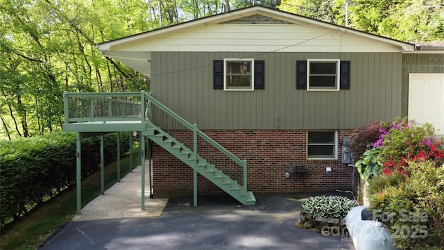 857 Country Club Dr, Maggie Valley, NC 28751 - rear view of house with stairs, a garage, and brick siding