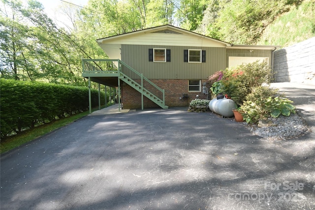 857 Country Club Dr, Maggie Valley, NC 28751 - rear view of house with stairway, a wooden deck, brick siding, and driveway