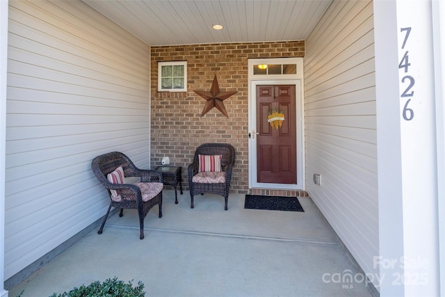 entrance to property with brick siding and covered porch