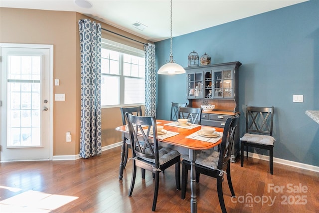dining room featuring baseboards, visible vents, and wood finished floors