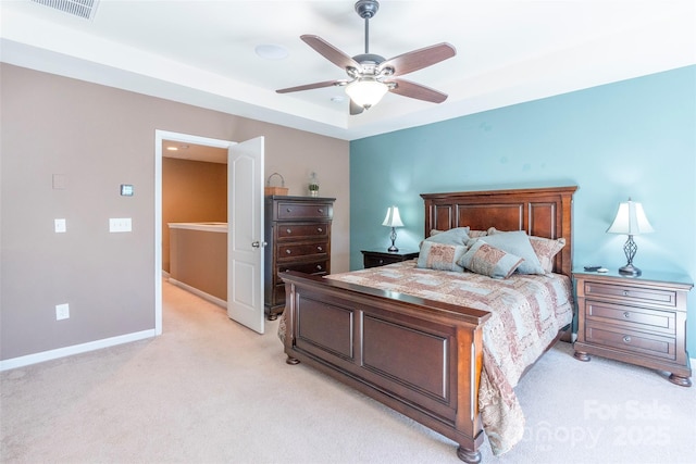 bedroom with visible vents, baseboards, a ceiling fan, a raised ceiling, and light colored carpet