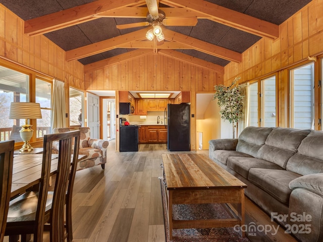 58 Country Cottage Ln, Canton, NC 28716 - living room featuring wood walls, light wood-style flooring, vaulted ceiling with beams, and ceiling fan