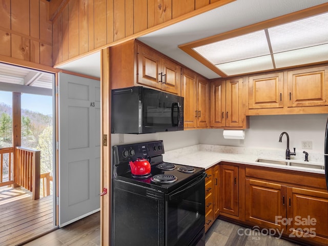 58 Country Cottage Ln, Canton, NC 28716 - kitchen featuring a sink, dark wood-style flooring, light countertops, brown cabinetry, and black appliances
