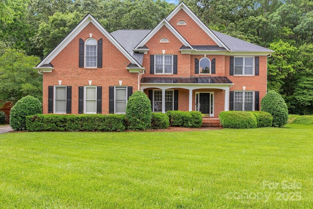 1102 High Brook Dr, Waxhaw, NC 28173 - colonial-style house featuring brick siding, a front yard, covered porch, and view of scattered trees