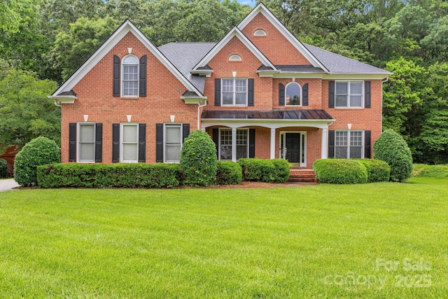 1102 High Brook Dr, Waxhaw, NC 28173 - colonial inspired home featuring brick siding, a front yard, covered porch, and view of wooded area
