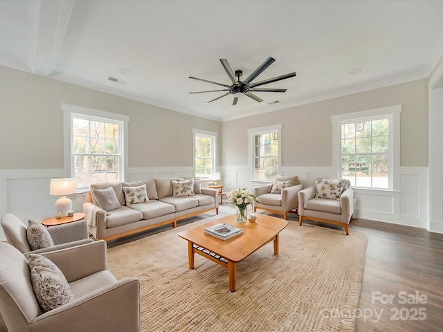 living area with visible vents, wood finished floors, ceiling fan, and a healthy amount of sunlight